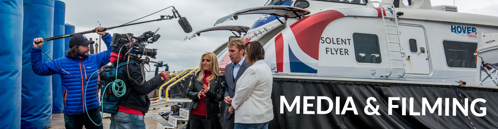 People being filmed in front of a hovercraft